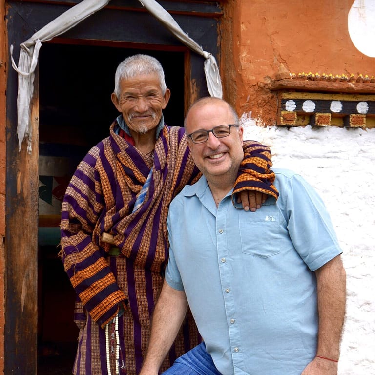 Allan Harari photographed next to Asian local in village, implying partnership and trust